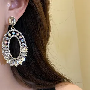 Close-up of elegant silver needle oval dangle earrings with shimmering rhinestones