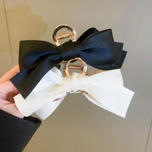 Dettaglio di eleganti mollette per capelli con fiocco in bianco e nero per acconciature