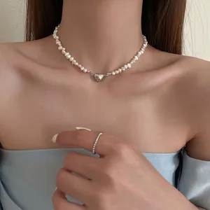 Elegant freshwater pearl necklace with silver heart magnetic clasp on model.