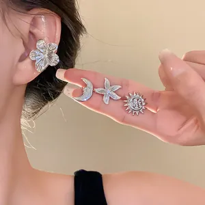 Detailed view of silver celestial ear cuffs including starfish, moon, and sun motifs