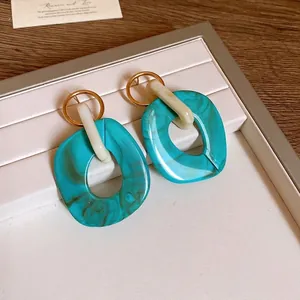 Orecchini geometrici vintage in acrilico turchese marmorizzato su vassoio portagioie