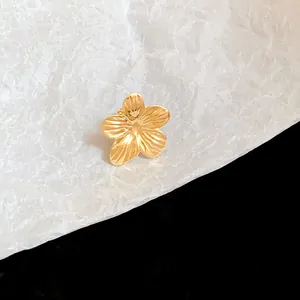 Macro detail of elegant gold-toned flower-shaped metal ear clip earring for women