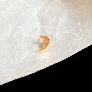 Gold-colored crescent moon ear cuff with a detailed facial expression and metallic finish.