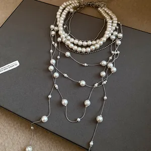 Detail of multi-layered pearl tassel necklace with silver beads and elegant drapes.
