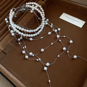 Detail view of elegant double-layered pearl necklace with long silver-tone tassels.