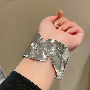 Detailed view of an irregular geometric metallic open cuff bracelet on a female wrist