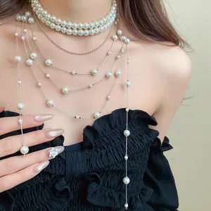 Detailed macro view of an elegant layered pearl tassel necklace on a model's neckline