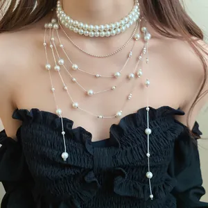 Double-layered pearl necklace with long tassels worn by a model in black dress