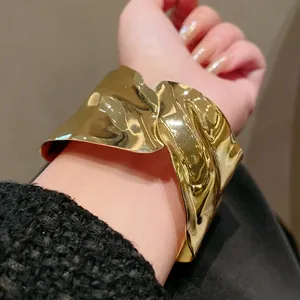 Close-up of gold irregular geometric open cuff bracelet with metallic texture