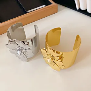 Brazaletes abiertos con flores en acabados oro y plata con elegantes detalles de perlas