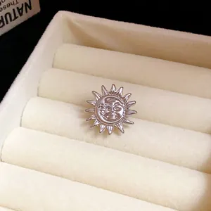 Close-up view of silver celestial sun and moon ear clip in cream jewelry box