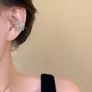 Close-up detail of a silver sun and moon metal ear cuff non-pierced earring accessory