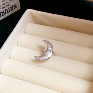 Close-up detail of a silver crescent moon ear cuff featuring a vintage facial profile design
