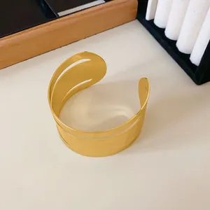 Detalle de los elegantes patrones recortados en un brazalete dorado de estilo minimalista