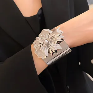 Primer plano del gran brazalete de flor plateada con perla sobre americana negra