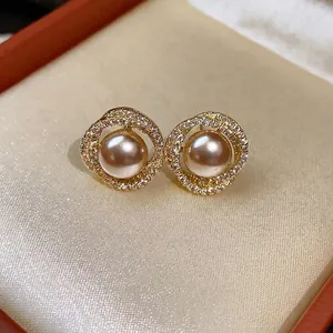 Elegant gold plated stud earrings featuring a central pearl and micro-pave zirconia.