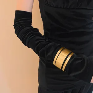 Primer plano de un elegante brazalete ancho de metal dorado sobre terciopelo negro