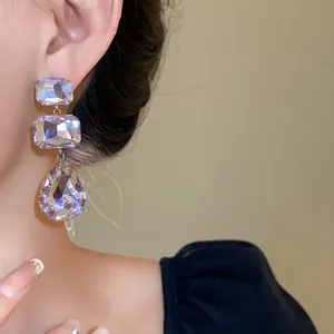 Vista dettagliata di eleganti orecchini in argento con cristalli quadrati e a goccia