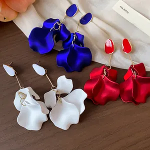 Macro view of exquisite acrylic flower petal earrings in vibrant blue, red, and white.