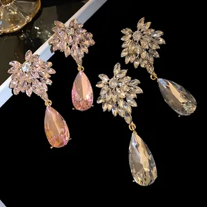Detailed view of sparkling flower-shaped studs and large crystal teardrop pendants