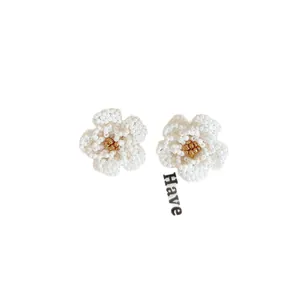 Elegant white beaded camellia flower stud earrings featuring a delicate golden center beads