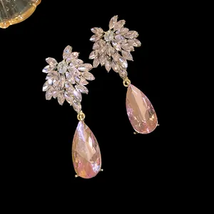 Macro view of elegant pink crystal teardrop earrings with sparkling floral diamond accents