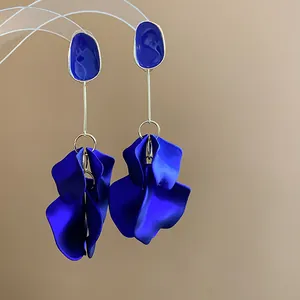 Detailed shot of vibrant blue acrylic petal drop earrings with gold-toned metal accents