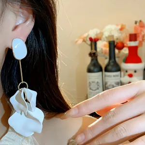 Close-up detail of stylish white acrylic petal drop earrings worn for an elegant look