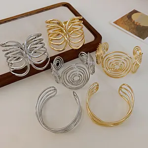 Detailed view of minimalist multi-layer criss-cross open cuff bracelets in gold and silver