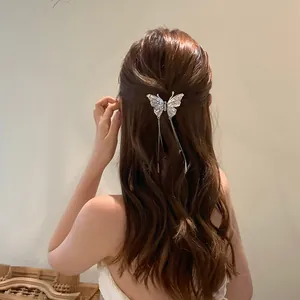 Detail view of an elegant butterfly hair clip with rhinestones and long tassels on hair