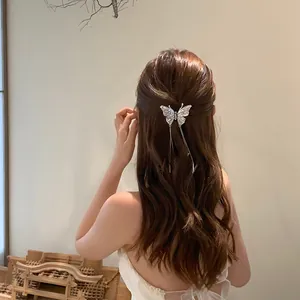 Detailed close-up showing a sparkling butterfly hair clip with tassels on styled hair
