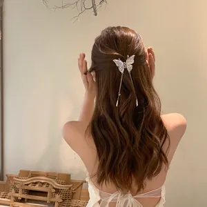 Elegant silver butterfly hair clip with tassel detail shown on long brunette hair