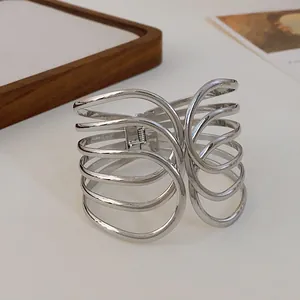 Detailed close-up view of a silver multi-layer criss-cross open cuff bracelet