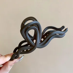 Macro view of the elegant matte finish and wavy curves of a stylish brown hair claw clip.