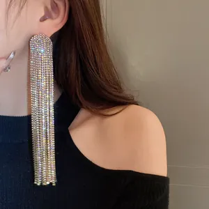 Detailaufnahme glitzernder Ohrringe mit langen Quasten und Strasssteinen.
