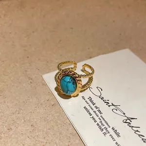 Detailed macro view of a vintage gold-plated turquoise open ring on a decorative card