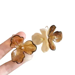 Elegant acrylic flower drop earrings with marble pattern and gold hooks on white background