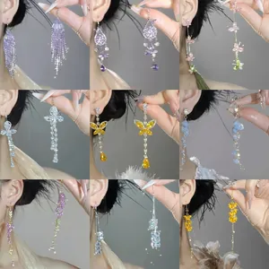 Collezione di eleganti orecchini pendenti stile fata con fiori e farfalle colorate
