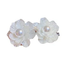 Elegant white floral stud earrings with central pearl and silver needles for women.