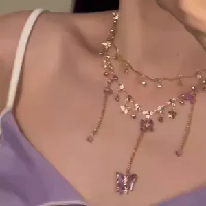 Detail view of a double-layered necklace with delicate purple resin butterfly pendants