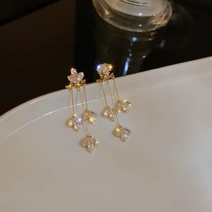 Primo piano di eleganti orecchini a nappa con cristalli floreali e foglie