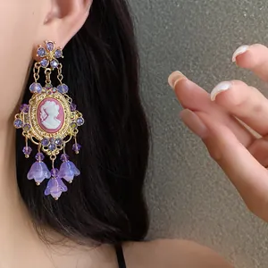 Vintage cameo earrings with purple rhinestones and floral tassels in palace style detail.