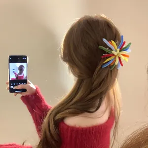 Colorful firework hair clip in flocking material shown on a woman's hair in a mirror.