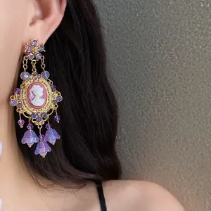 Detail of elegant vintage cameo earrings with purple rhinestones and floral tassels