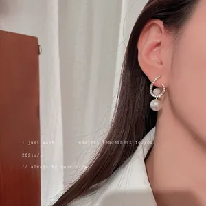 Elegant silver needle earrings with twisted rhinestone C-shape and hanging double pearls