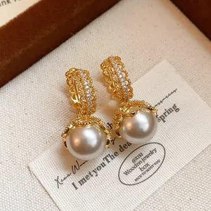 Detailed view of vintage gold-plated lace pearl hoop earrings with shiny CZ stones