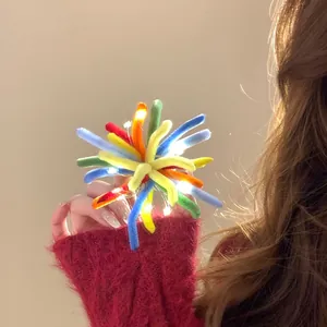 Detailed view of colorful flocked firework hair clip with glowing LED lights
