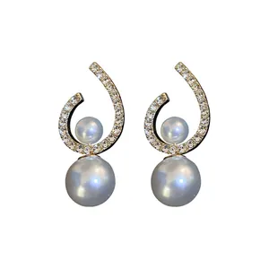 Elegant silver needle earrings with twisted rhinestone curves and double white pearls