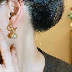 Close-up of French vintage gold-plated hoop earrings with elegant pearl drop detail
