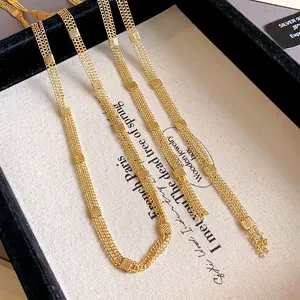 Detailed macro view of an elegant multi-strand golden long chain necklace for women